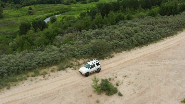 Aerial view of a car driving on sand