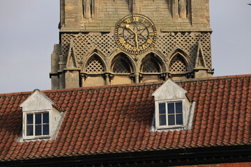 Old church clock with an old buildings roof with windows in front in Newark Nottinghamshire England