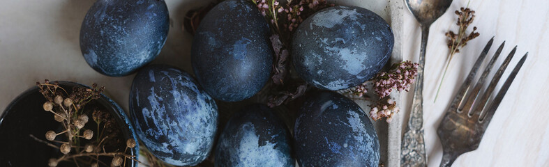 banner blue painted easter eggs on wooden table with vintage fork and dried flowers, easter...