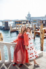 Naklejka premium Mom and daughter in fashionable dresses walk around Venice. Lifestyle, travel, tourism.