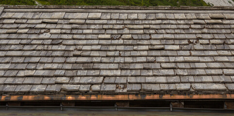 Detail of the roof of a mountain house with wooden tiles. Natural rustic background.