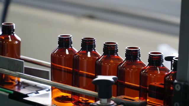 many bottles for bottling medicines. many small open brown glass oval pharmacy bottles close up