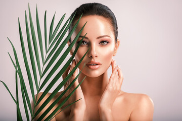 Young beautiful woman with green leaves near body. Skin care beauty treatments concept.  Closeup...