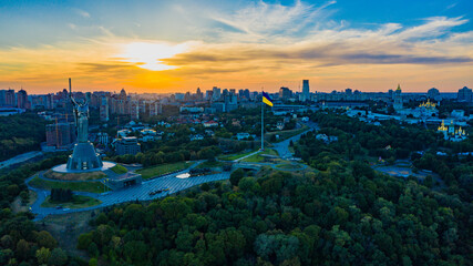 Aerial view to the  Beautiful landscape city Kiev with a Dnepr river while sunset. Top view to the city Kiev in the summer. Beautiful city Kiev while sunset.