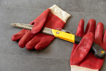 using gloves to prevent hand injuries while working in the workshop-saw and thick work gloves-
