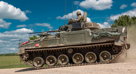 Fototapeta na wymiar close up of a British army Warrior FV510 light infantry fighting vehicle tank in action on a military exercise, blue sky with light clouds, Wiltshire UK
