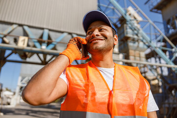 Multiethnic engineer talking on cellphone on construction site