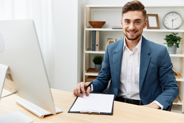 businessmen writes in documents at the desk in the office executive