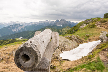 A wooden telescope for observing the top of the mountain. Hiking trail in Austria. In the background, snowy mountains. Flachau - 488242377