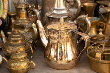 Copper antique jugs on the shelves, a collection of antique copper utensils