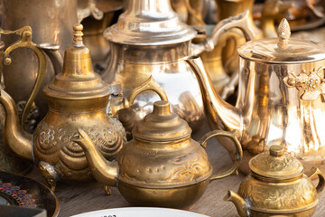 Fototapeta na wymiar Copper antique jugs on the shelves, a collection of antique copper utensils