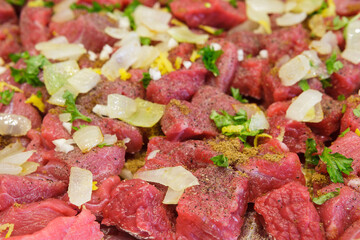 Raw meat with onion and spice ready for cooking, beef chopped into chunks
