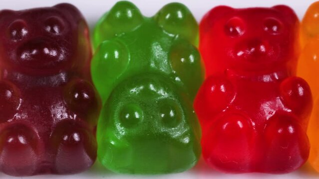 Macro view slider shot of colorful gummy bear shaped candies.candy background. Colorful jelly sweets.candies texture pattern close up footage.
