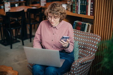 Young caucasian woman working via laptop at the cafeteria