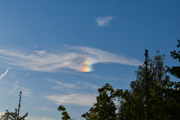 a beautiful and bright sun halo also known as sundog, with cirrus clouds on a blue sky