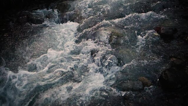 Slow motion of Norwegian mountain river , stream flowing through rocks. Close up of river stones with flowing water, clean water flowing in a mountain river at the Norway