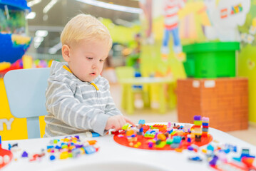 Fototapeta na wymiar little boy play colorful cubes puzzle at the table