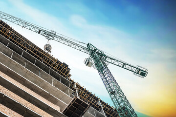 Construction crane on the construction of a monolithic house on a background of beautiful sky