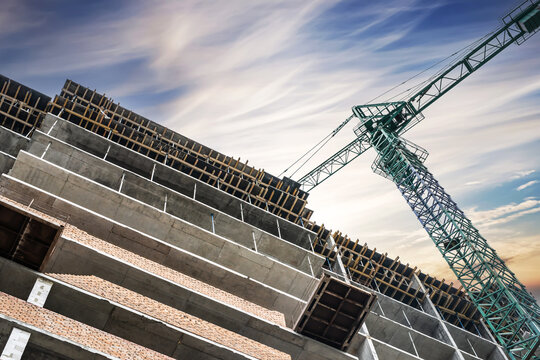 Construction crane on the construction of a monolithic house on a background of beautiful sky