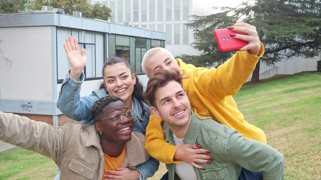  Group of multicultural college student friends taking a selfie on campus. 