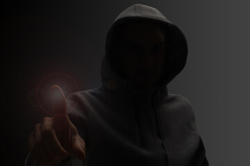 Close up portrait of a courageous man in a deep dark hood on a black background. The concept of secrecy of secrets and people hiding from the government. Hackers and thieves. Low key.