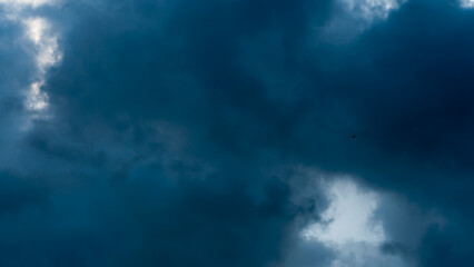 Obraz premium timelapse movement black storm clouds cover the sky. Scary black clouds during a hurricane and thunder. The weather is waiting for rain.