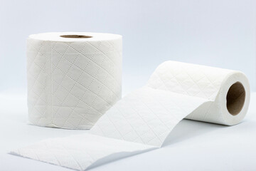 Two rolls of perforated toilet paper on a light background