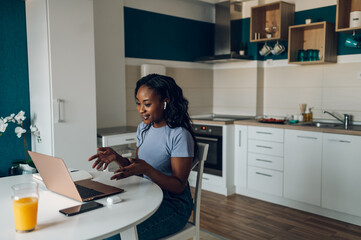 Young african american woman working from home and using a laptop