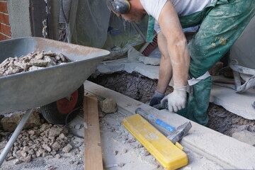 A man working in a hole digging deepper.