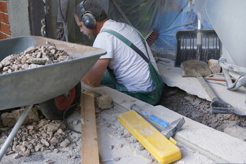 A man taking away crushed stones and betong.