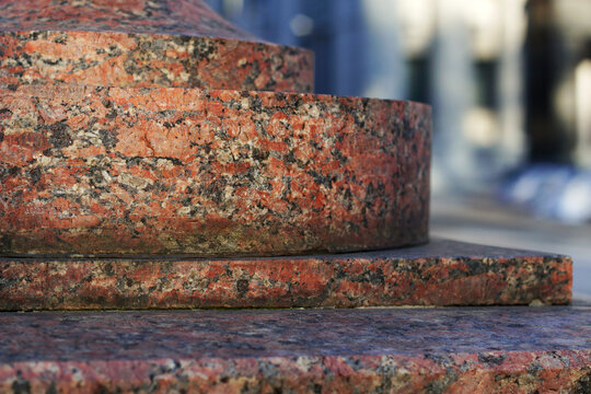 red granite postament in the city as a stone background