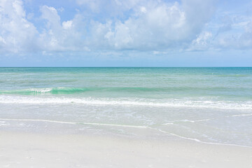 Beach in Naples in Southwest Florida with turquoise blue green idyllic water on summer day gulf of mexico coast horizon in paradise landscape nobody