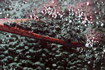 Blueberries on a wooden spoon. The process of making jam. Harvesting sweet fresh berries for the winter.