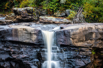 Closeup long exposure water flowing view on Blackwater Falls famous waterfall in West Virginia State Park at autumn fall season