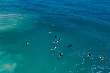 Obraz premium Surfers with surfboards in blue wave. Aerial view in Brazil