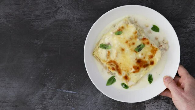 Serving Chicken Lasagna with Basil and Creamy White Sauce