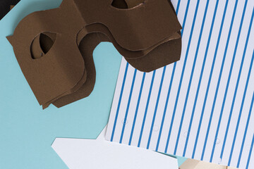 pile of paper masks and blue paper (some with stripes)