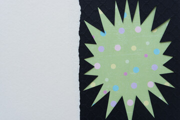 irregular abstract shape (starburst, sun) - black on green with dots and white space