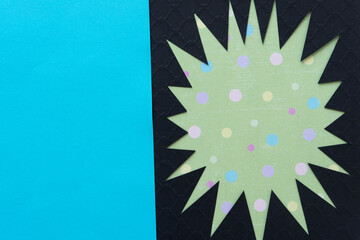 irregular abstract shape (starburst, sun) - black on green with dots and blue space