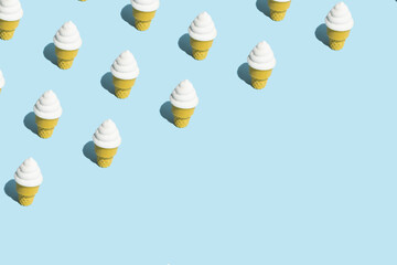 Trendy sunlight Summer pattern made with vannila ice cream on bright light blue background. Minimal summer concept. Copy space.