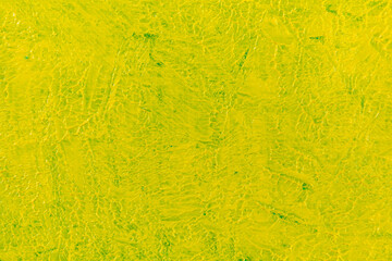 abstract bright colored background: yellow paint on blue fabric close