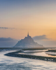 Moody sunrise at Le Mont Saint Michel abbey on the island in foggy morning, Normandy, Northern...