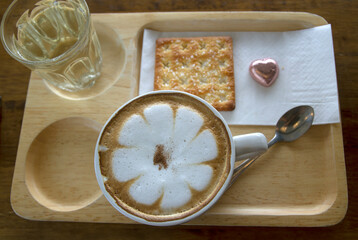 Hot cappuccino in a wooden tray and biscuits