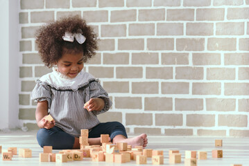 Young black girl is having fun playing and learning to strengthen her cognitive skills at home.