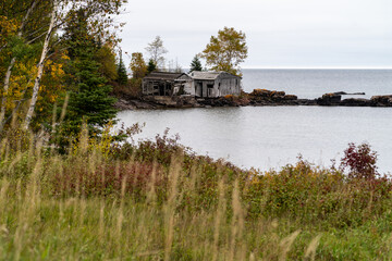 Abandoned fishing shacks or cabins, on Two Fishhouse Beach along Lake Superior shoreline in Minnesota, during fall