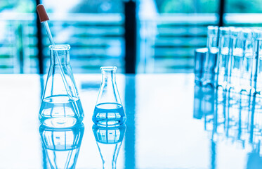 Two science flasks of different sizes contain on white desk.