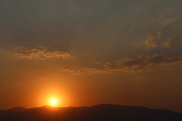 atardecer detras de las montañas en un cielo limpio