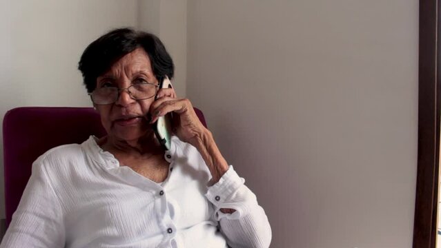 older adult latin woman talking on cell phone
