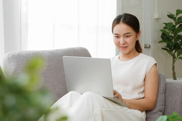 Young Asian woman working, shopping online,  with laptop computer at home