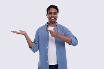 Man Holding Hand to Side Pointing at It Watching to Camera Isolated. Indian Man Smilling. Commercial, Advertisment Concept